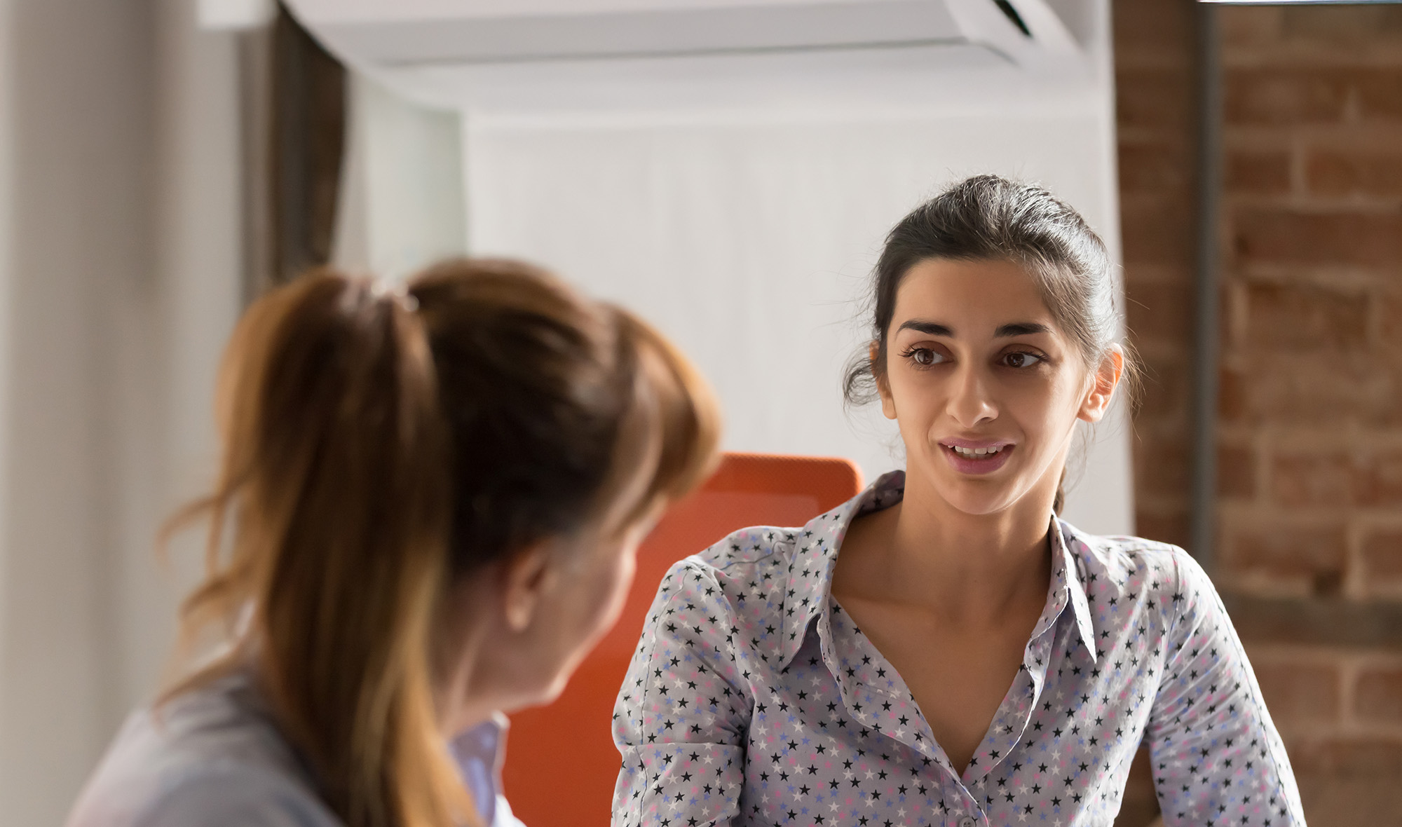 Indian businesswoman speaking to colleague during a job interview