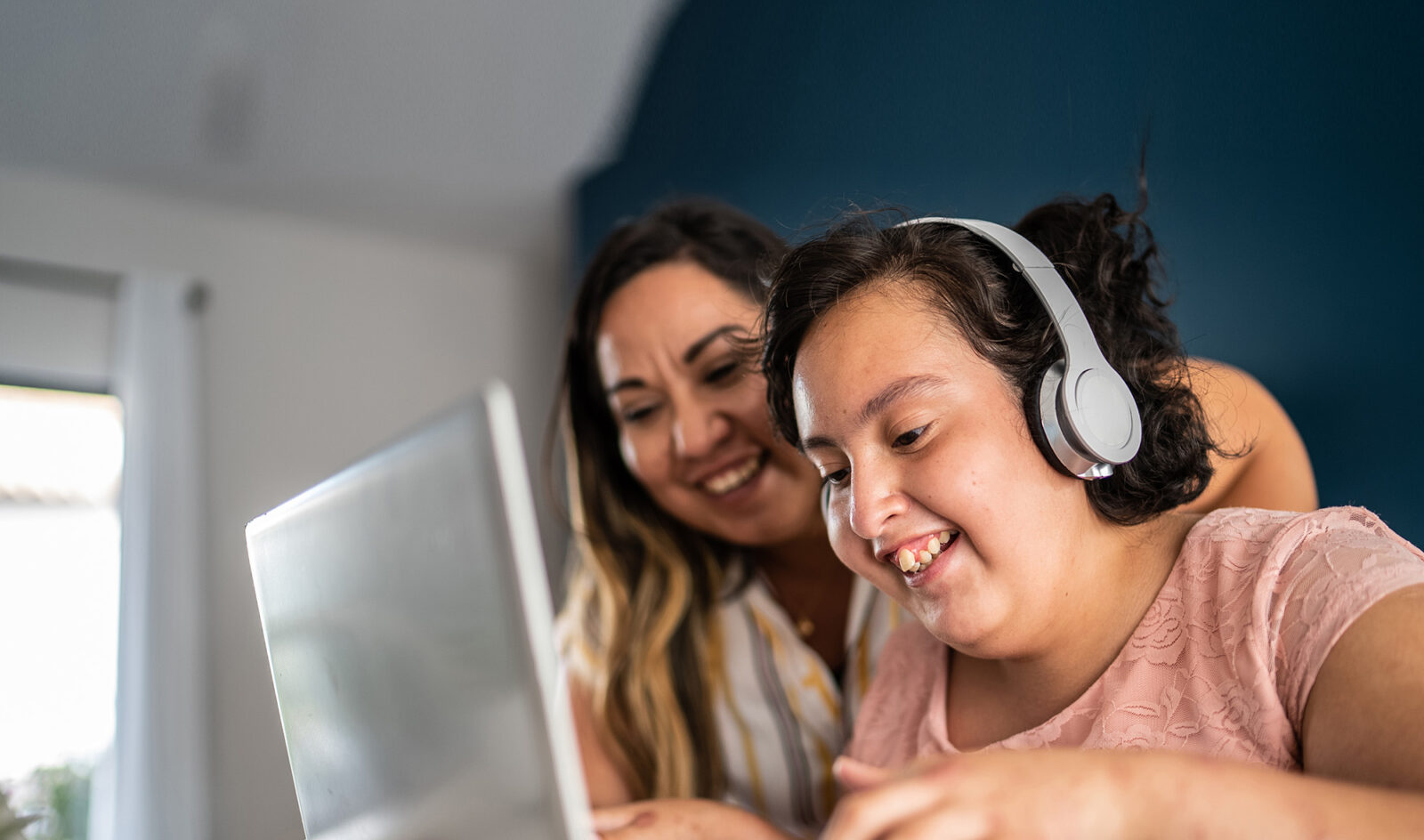 Mother helping psychomotor Intellectual disability girl using laptop studying at home